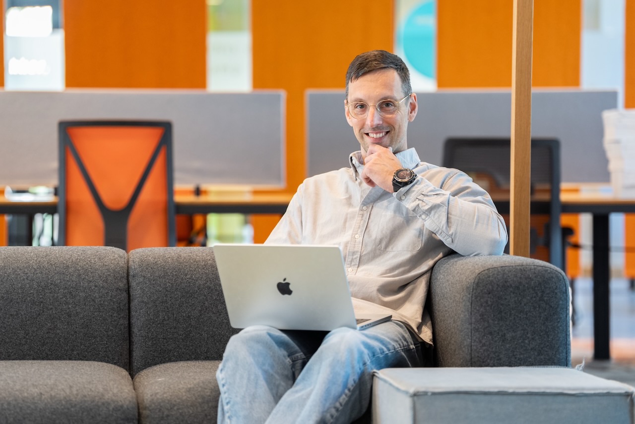 Matthijs van Meurs werkt op een laptop op een bank in een kantoor